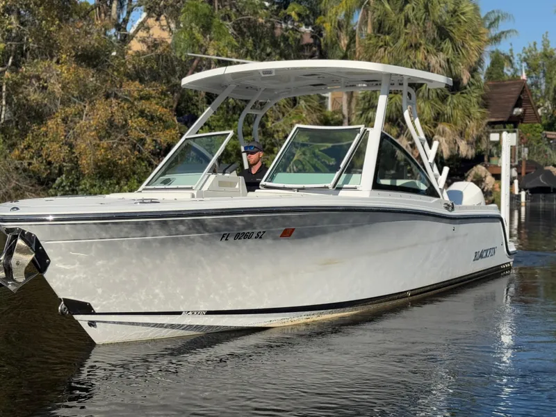 Slide: The Image of 2021 Blackfin 252DC boat cruising on a calm waterway, surrounded by lush greenery. - 19