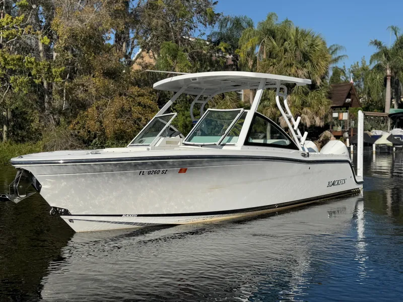 Slide: The Image of 2021 Blackfin 252DC boat on calm water, surrounded by lush greenery. - 20
