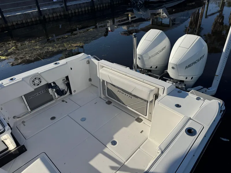 Slide: The Image of 2021 Blackfin 252DC boat with dual Mercury engines, docked by the water. - 35