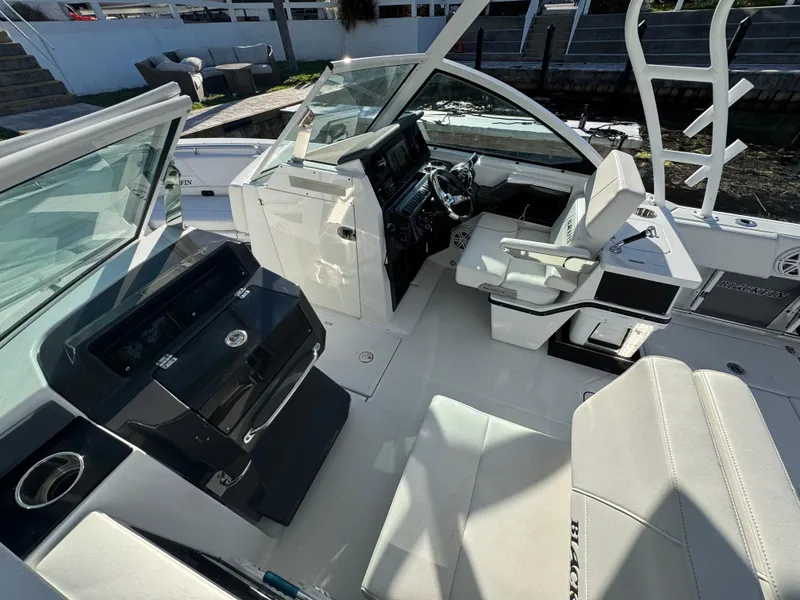 Slide: The Image of 2021 Blackfin 252DC boat interior with helm, seating, and modern dashboard. - 37