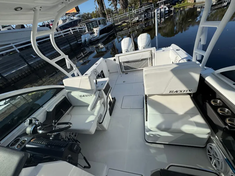 Slide: The Image of 2021 Blackfin 252DC boat interior with seating and helm, docked by the water. - 43