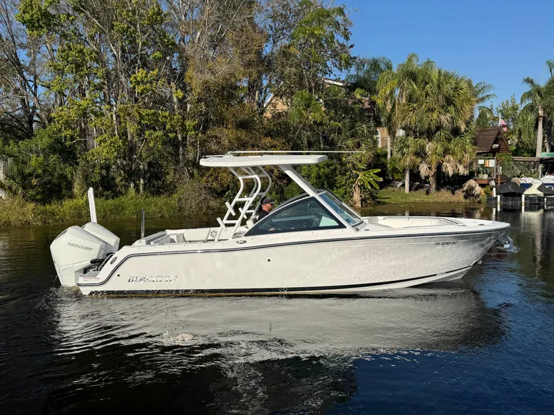 Slide: The Image of 2021 Blackfin 252DC boat cruising on a calm river with lush greenery. - 8