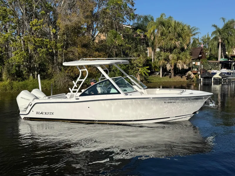 Slide: The Image of 2021 Blackfin 252DC boat on a calm river, surrounded by lush greenery. - 9