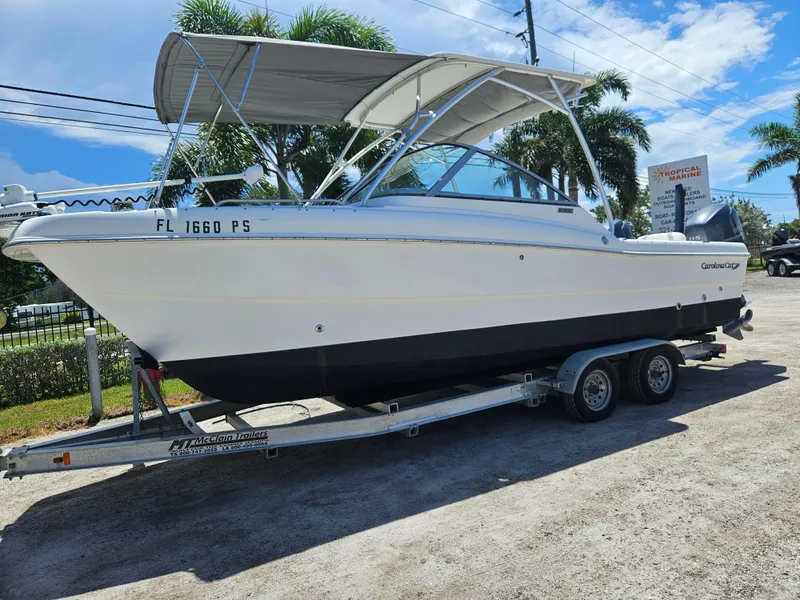 The Image of 2014 Carolina Cat 230 DC boat on trailer, parked outdoors under sunny skies. - 0