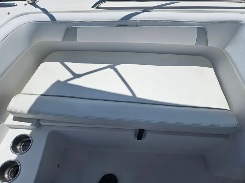 Slide: The Image of 2014 Carolina Cat 230 DC boat interior with white cushioned seating and cup holders. - 10