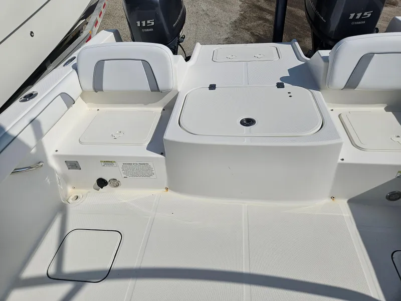 Slide: The Image of 2014 Carolina Cat 230 DC boat interior with dual 115 engines, spacious seating, and storage compartments. - 12