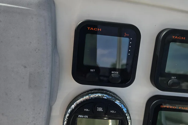 Slide: The Image of Dashboard of a 2014 Carolina Cat 230 DC boat with tachometer and JBL audio controls. - 17