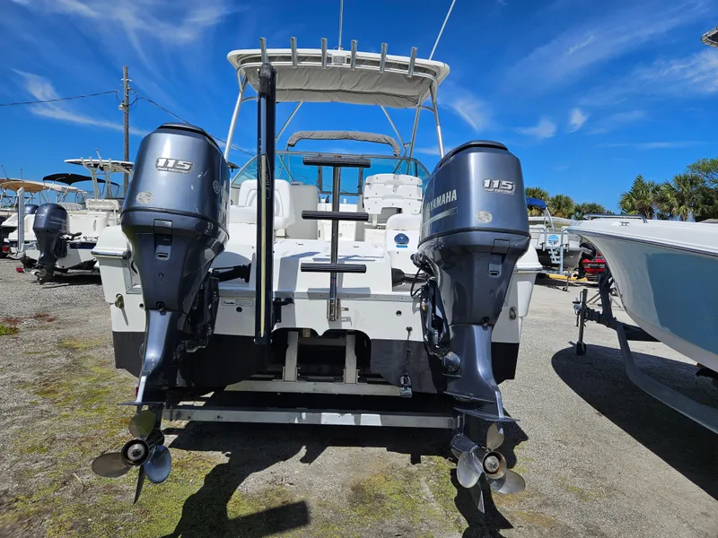 Slide: The Image of 2014 Carolina Cat 230 DC boat with dual Yamaha 115 engines, parked outdoors. - 18