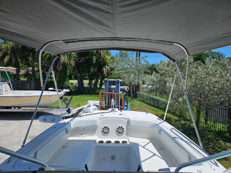 Slide: The Image of 2014 Carolina Cat 230 DC boat interior with canopy, parked outdoors. - 2