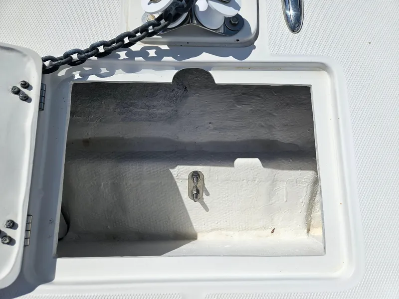 Slide: The Image of Open anchor locker on 2014 Carolina Cat 230 DC boat, showing chain and latch. - 23