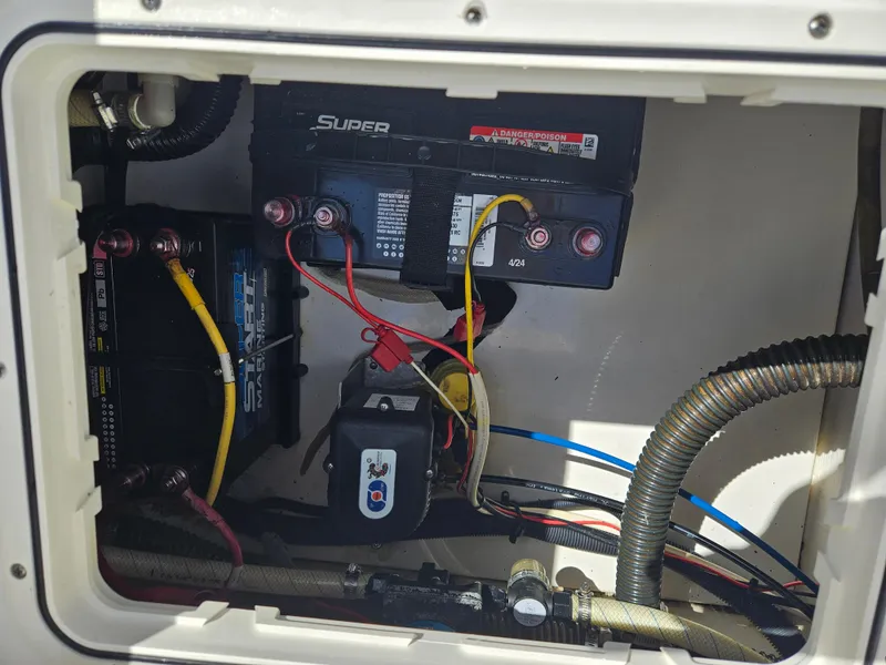 Slide: The Image of Battery compartment of a 2014 Carolina Cat 230 DC boat with wiring and connections. - 26