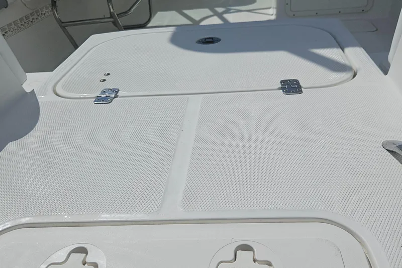 Slide: The Image of 2014 Carolina Cat 230 DC boat deck with storage compartments and textured surface. - 30