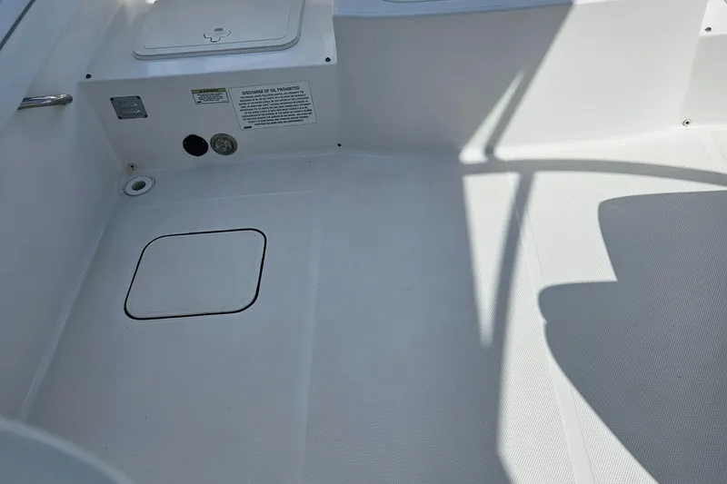 Slide: The Image of 2014 Carolina Cat 230 DC boat deck with storage hatch and safety instructions. - 31