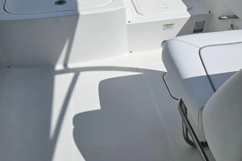 Slide: The Image of Interior of a 2014 Carolina Cat 230 DC boat, featuring white seating and flooring. - 32