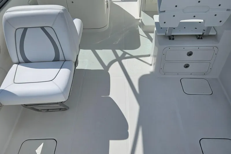 Slide: The Image of 2014 Carolina Cat 230 DC boat interior with white seating and storage compartments. - 34