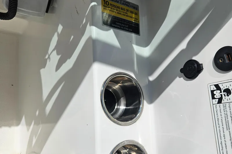 Slide: The Image of Interior of a 2014 Carolina Cat 230 DC boat showing cup holders and capacity label. - 36