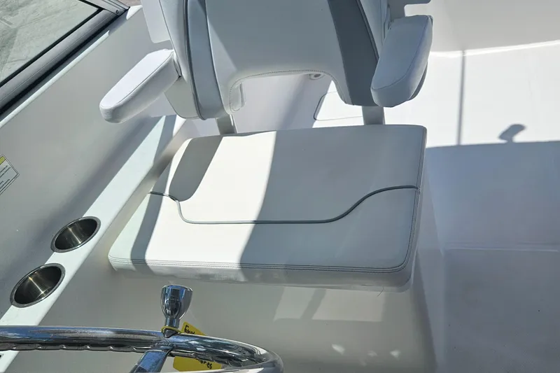 Slide: The Image of 2014 Carolina Cat 230 DC boat interior with white seating and cup holders. - 6