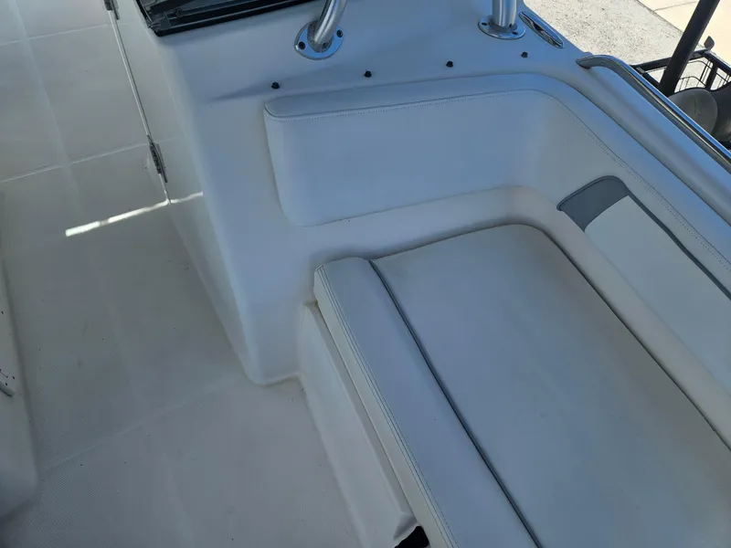 Slide: The Image of 2014 Carolina Cat 230 DC boat interior with white seating and stainless steel handrails. - 7