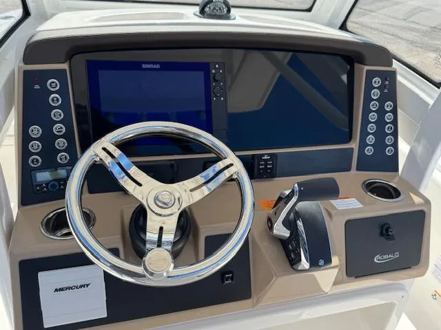 Slide: The Image of 2025 Robalo 266 Cayman helm with steering wheel, controls, and navigation display. - 12
