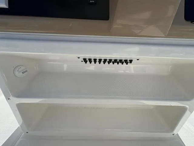 Slide: The Image of 2025 Robalo 266 Cayman boat console with storage compartments and control panel. - 16