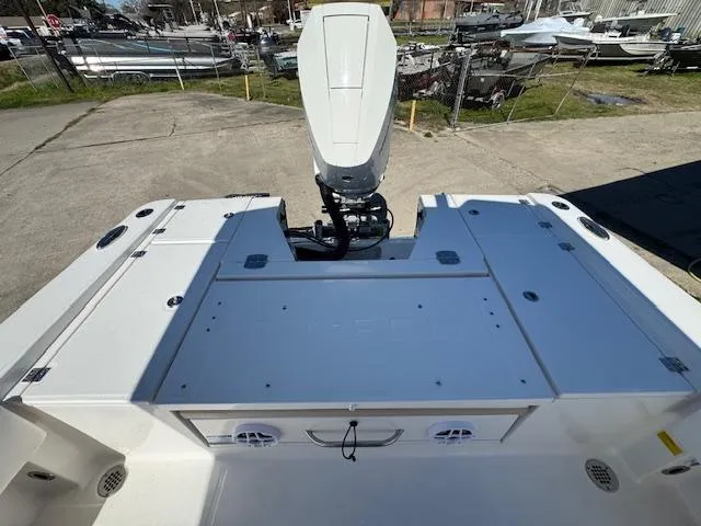 Slide: The Image of 2025 Robalo 266 Cayman boat deck with outboard motor, docked in a marina. - 19
