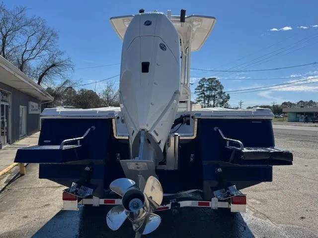 Slide: The Image of 2025 Robalo 266 Cayman boat, rear view with outboard motor, parked on a trailer. - 2