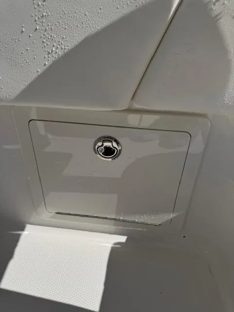 Slide: The Image of 2025 Robalo 266 Cayman boat storage compartment with lock, white finish. - 27