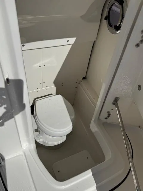 Slide: The Image of 2025 Robalo 266 Cayman boat interior with compact marine toilet. - 8