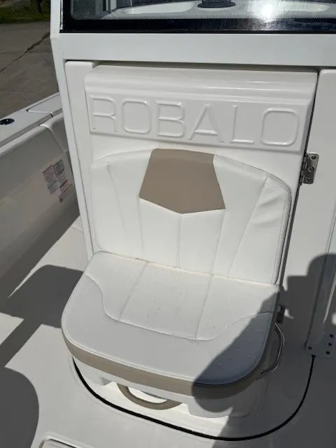 Slide: The Image of 2025 Robalo 266 Cayman boat seat with embossed logo, white and beige design. - 9