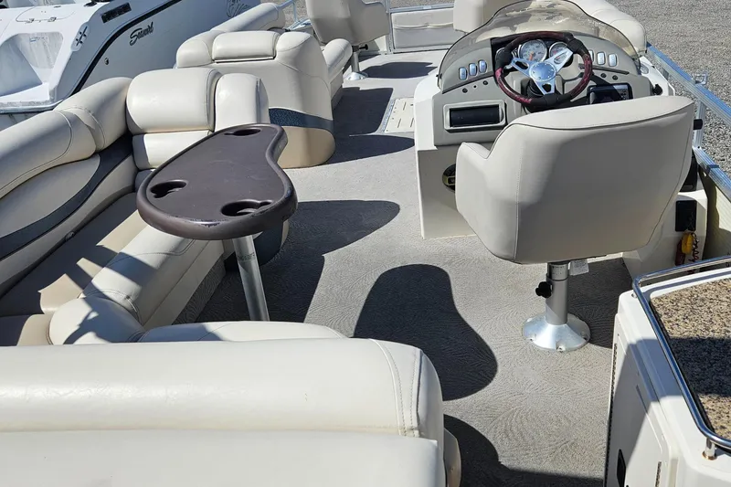 Slide: The Image of 2007 Bennington 2577RFS boat interior with beige seating and steering console. - 13