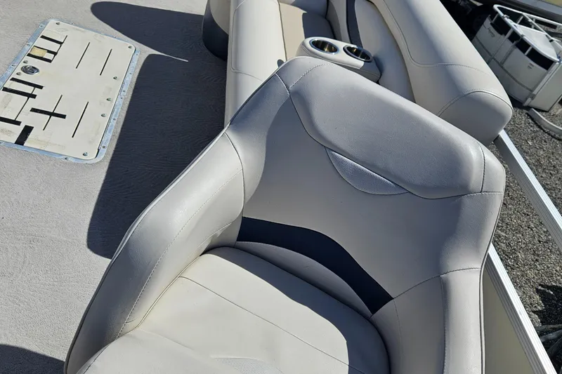 Slide: The Image of 2007 Bennington 2577RFS boat interior with beige seating and cup holders. - 15