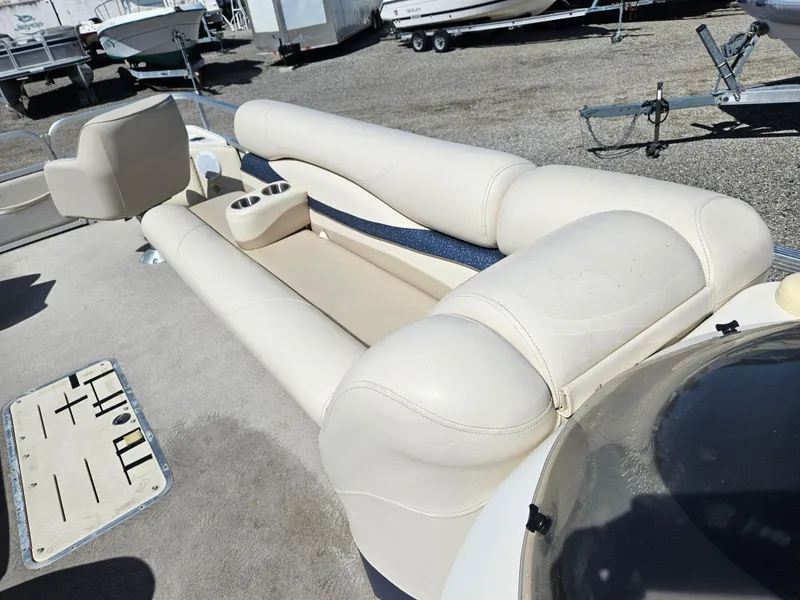 Slide: The Image of 2007 Bennington 2577RFS boat interior with beige seating and cup holders. - 6