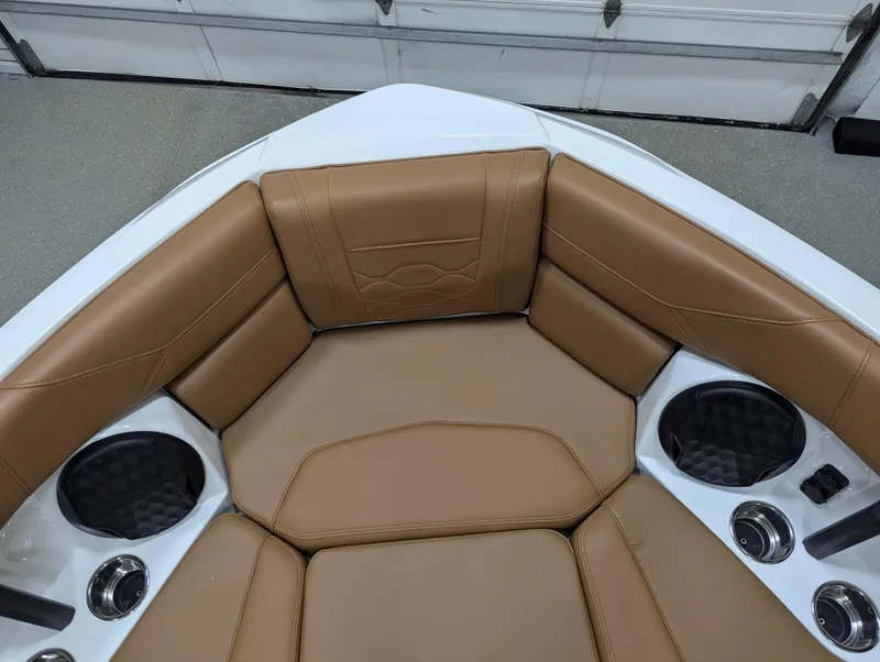 Slide: The Image of 2025 Malibu Wakesetter 23 LSV boat interior with tan leather seating and cup holders. - 20