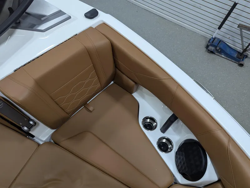 Slide: The Image of 2025 Malibu Wakesetter 23 LSV interior with tan leather seats and cup holders. - 21