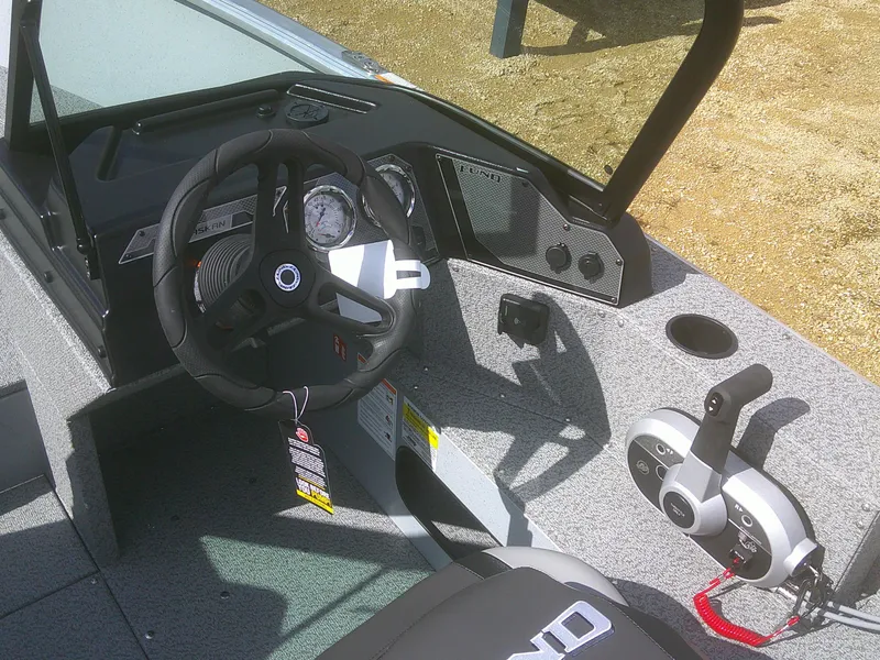 Slide: The Image of 2025 Lund 2075 Alaskan Sport boat interior with steering wheel and controls. - 15