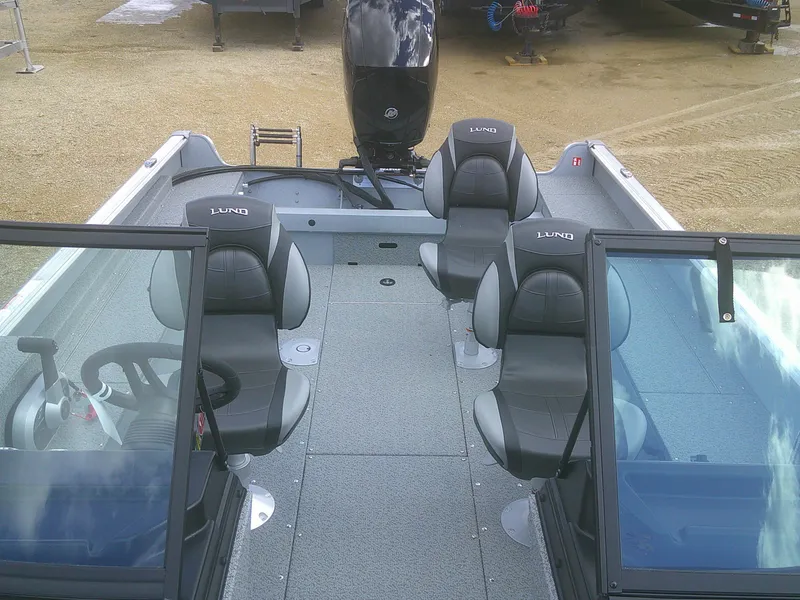 Slide: The Image of 2025 Lund 2075 Alaskan Sport boat interior with seating and steering wheel. - 9