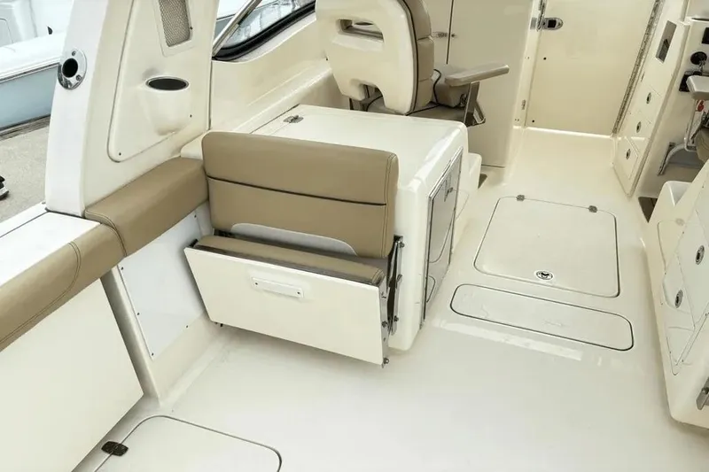 Slide: The Image of 2015 Scout 275 Dorado interior with beige seating and storage compartments. - 21
