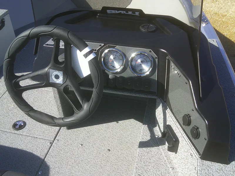 Slide: The Image of 2025 Lund 1675 Alaskan SS boat dashboard with steering wheel and gauges. - 11