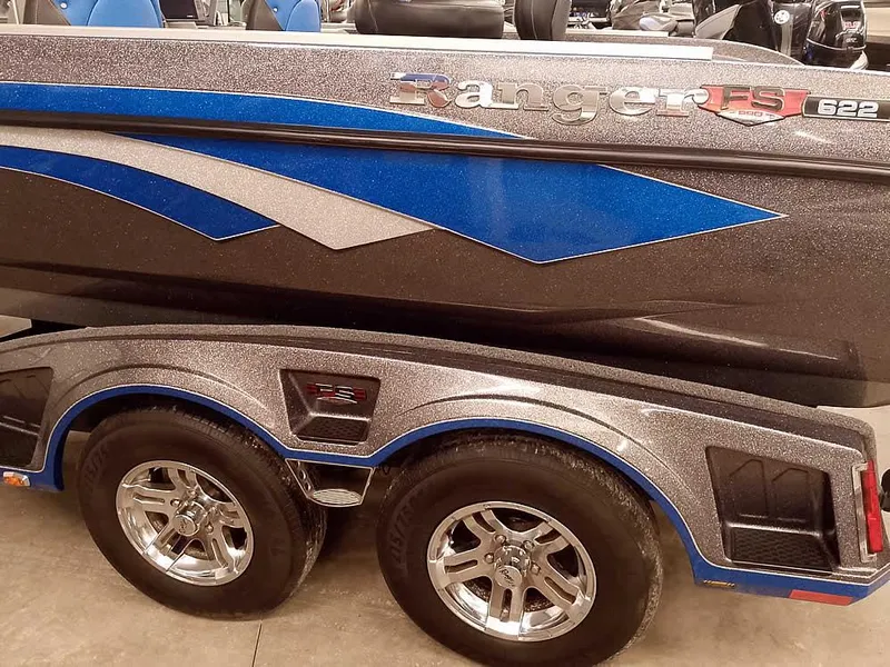 Slide: The Image of 2021 Ranger 622FS Pro boat with blue and gray design on a dual-axle trailer. - 11