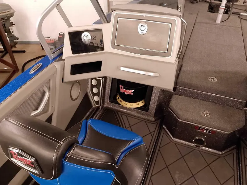 Slide: The Image of 2021 Ranger 622FS Pro boat interior with blue and black seating, dashboard, and storage compartments. - 32