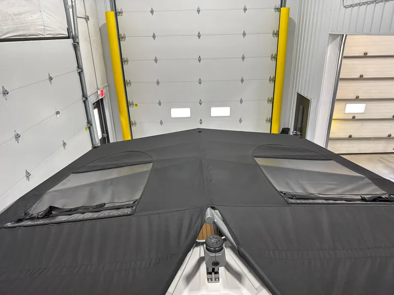 Slide: The Image of 2025 Nautique Super Air Nautique S23 boat covered in a garage. - 12