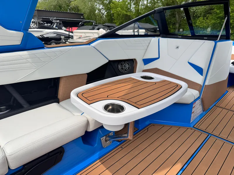Slide: The Image of 2025 Nautique Super Air Nautique S23 interior with sleek seating and wooden table. - 14