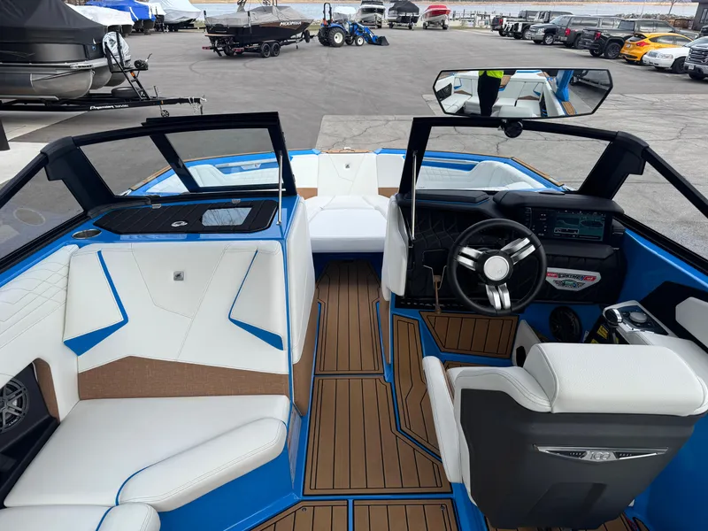 Slide: The Image of 2025 Nautique Super Air Nautique S23 interior with blue accents and modern dashboard. - 17