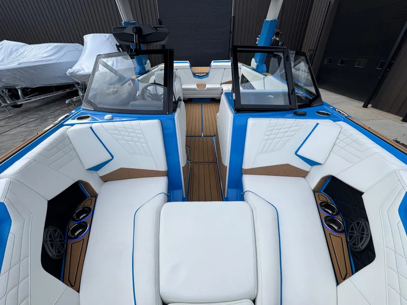 Slide: The Image of 2025 Nautique Super Air Nautique S23 interior with white and blue seating, wood accents. - 20