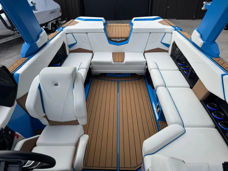 Slide: The Image of 2025 Nautique Super Air Nautique S23 interior with white seating and blue accents. - 21