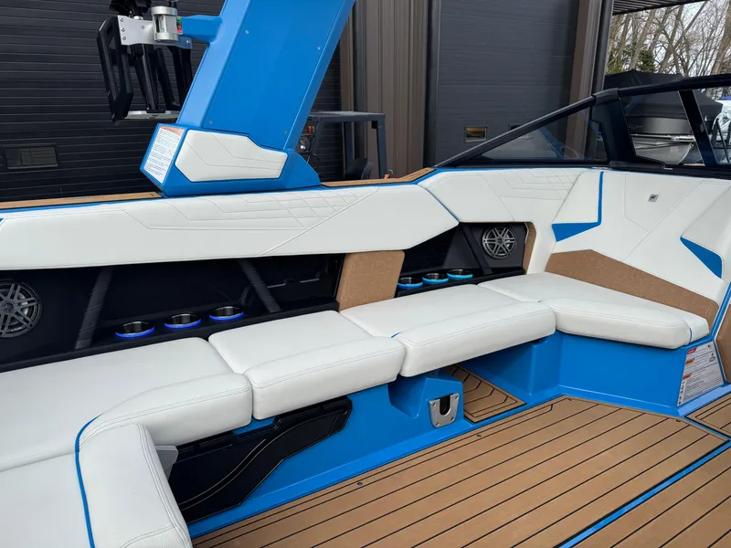 Slide: The Image of 2025 Nautique Super Air Nautique S23 interior with white seating and blue accents. - 22