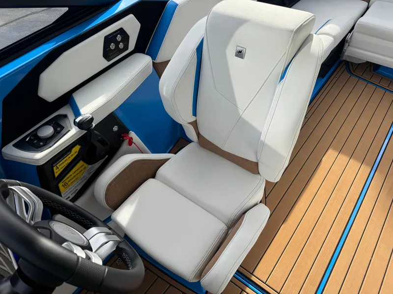Slide: The Image of 2025 Nautique Super Air Nautique S23 interior with white seating and modern dashboard. - 27
