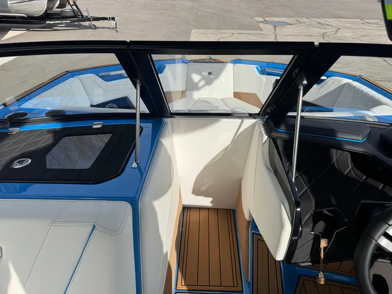 Slide: The Image of 2025 Nautique Super Air Nautique S23 interior with blue accents and teak flooring. - 30