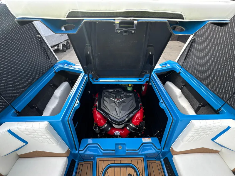 Slide: The Image of 2025 Nautique Super Air Nautique S23 engine compartment with vibrant red and black detailing. - 8