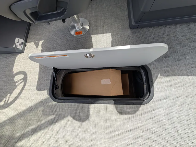 Slide: The Image of Storage compartment on 2025 Manitou Cruise boat with cardboard box inside. - 21